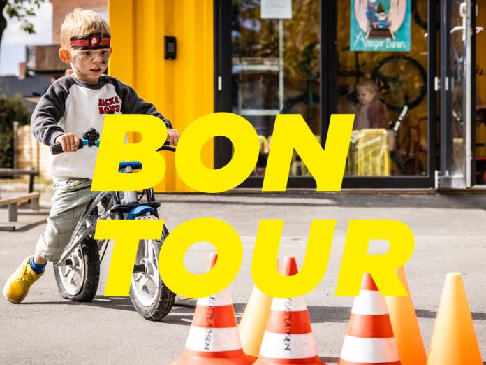Barn på cykel ved forhindringsbane med teksten ''bon tour''