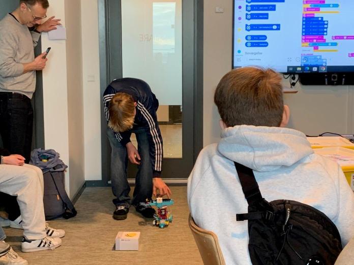 Unge afprøver en hjemmelavet robot i et klasselokale 