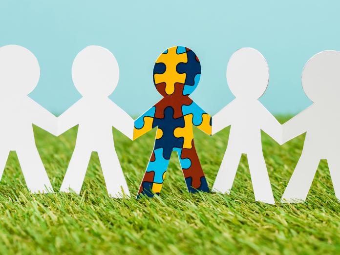 Modelbillede af udklippede papirmænd, hvoraf den ene er flerfarvet de andre er hvide-