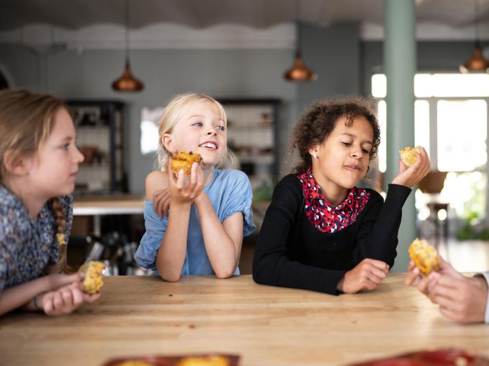 Børn der sidder og spiser ved et bord