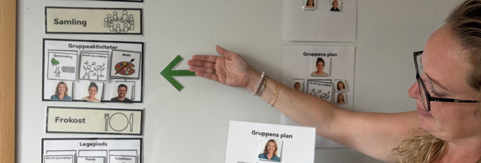En pædagog gennemgår tavlen for dagen
