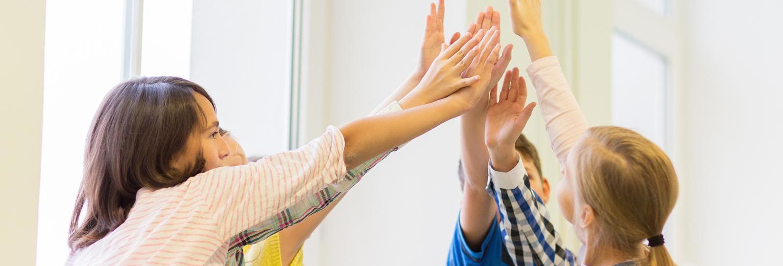 Seks børn giver highfive til hinanden